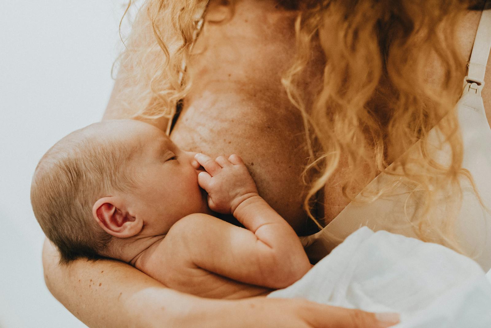 Woman Holding Child and Breastfeeding 