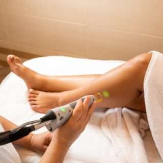 Close up of hair removal procedure on legs in salon. Laser epilation on beautiful female legs at beauty clinic