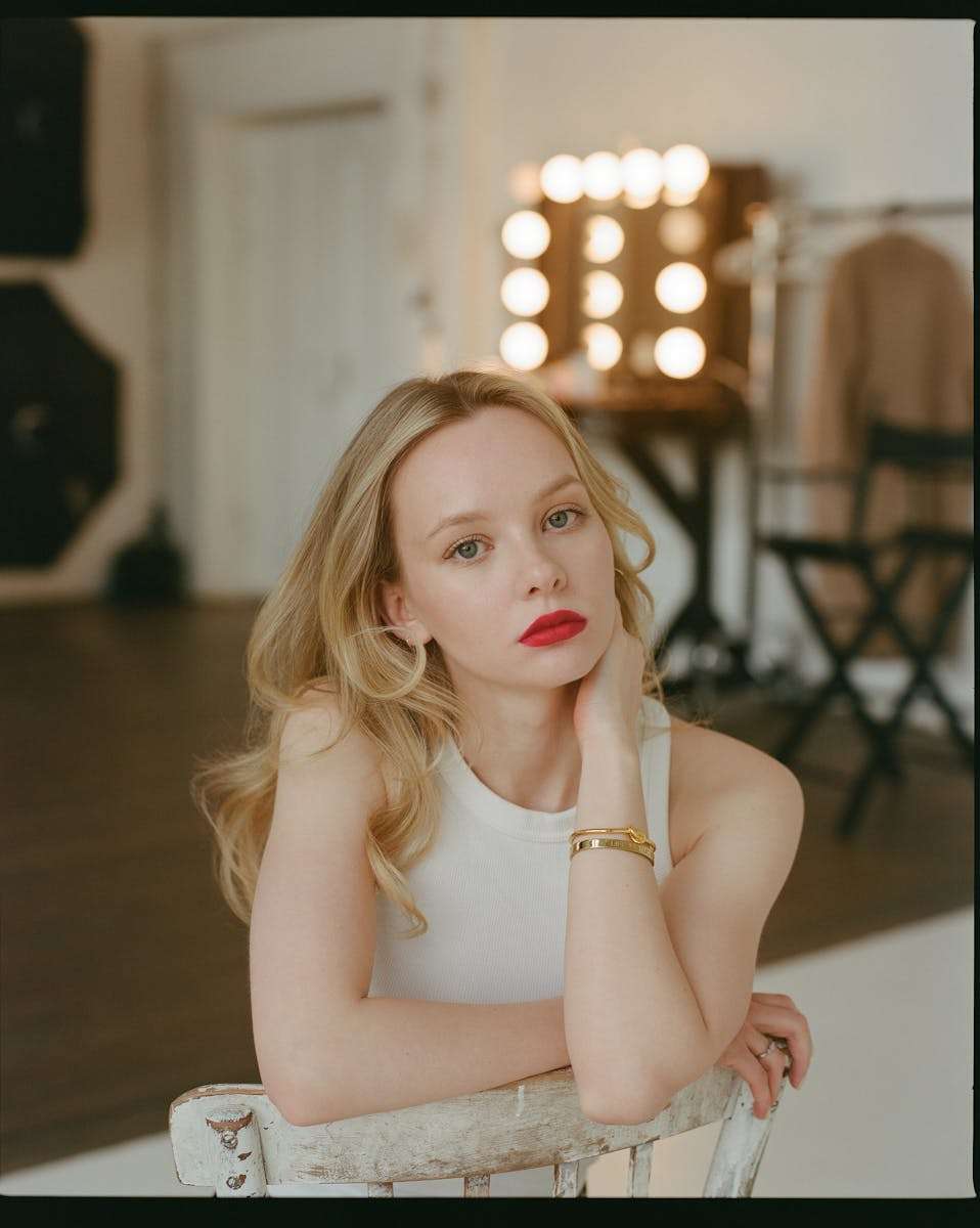 A woman with red lipstick sitting on a chair