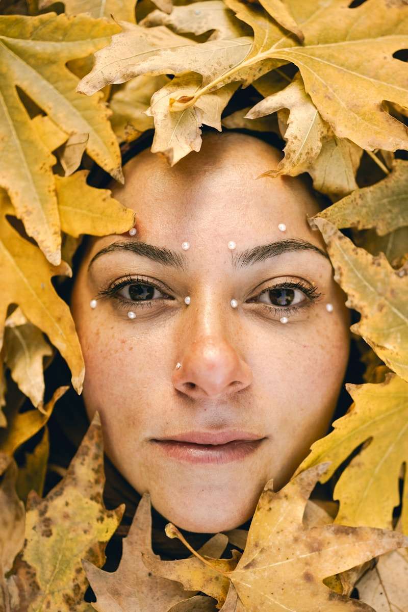 a woman with leaves covering her face