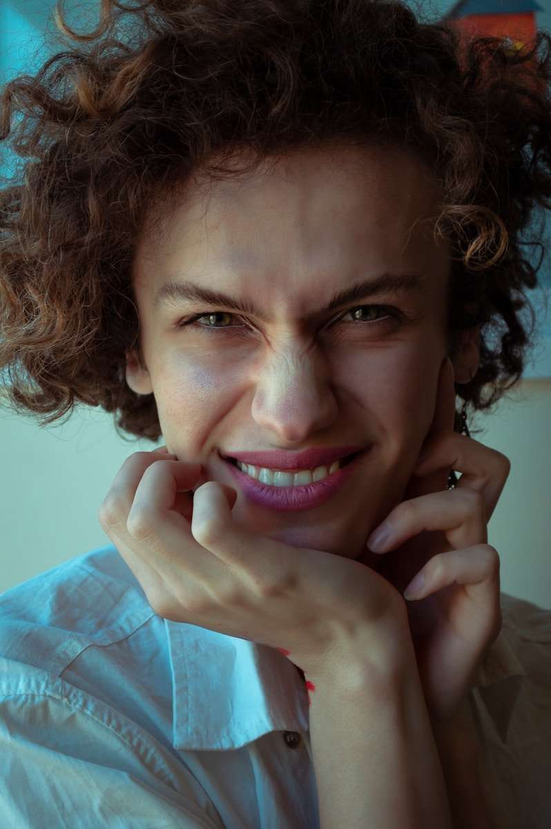 woman in blue dress shirt smiling