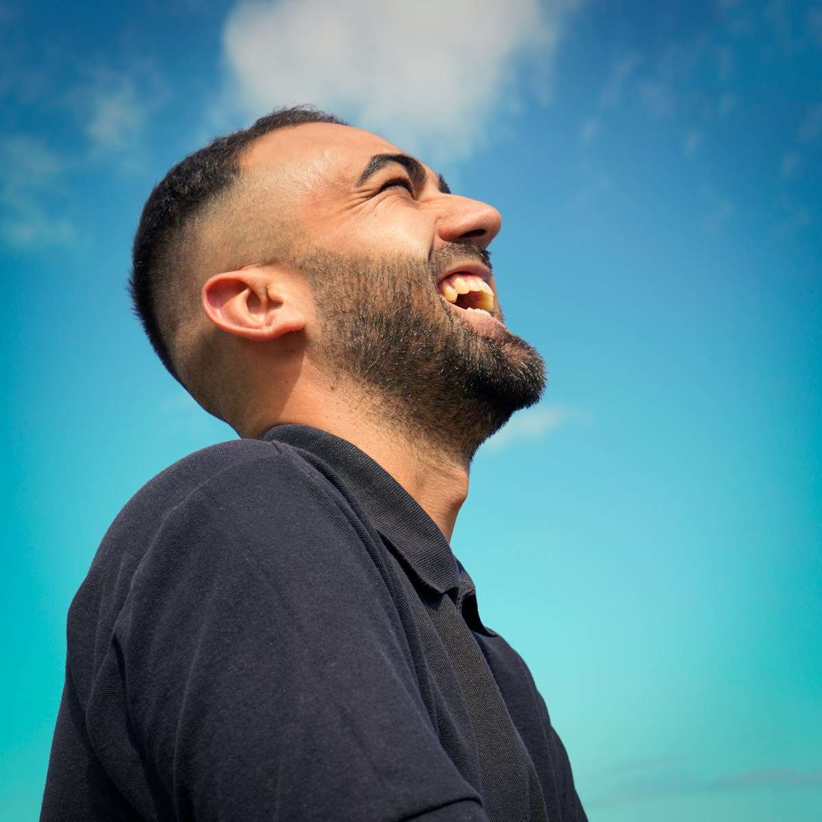 smiling man wearing black collared top