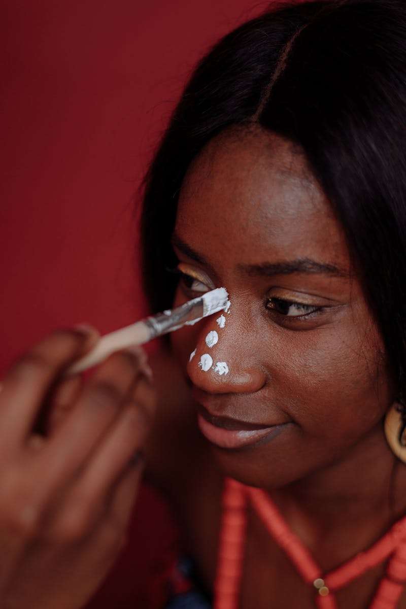 A Woman Applying Paint on Face