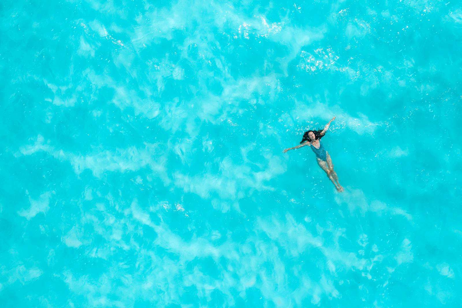 Aerial Photo of a Woman Floating in the Ocean